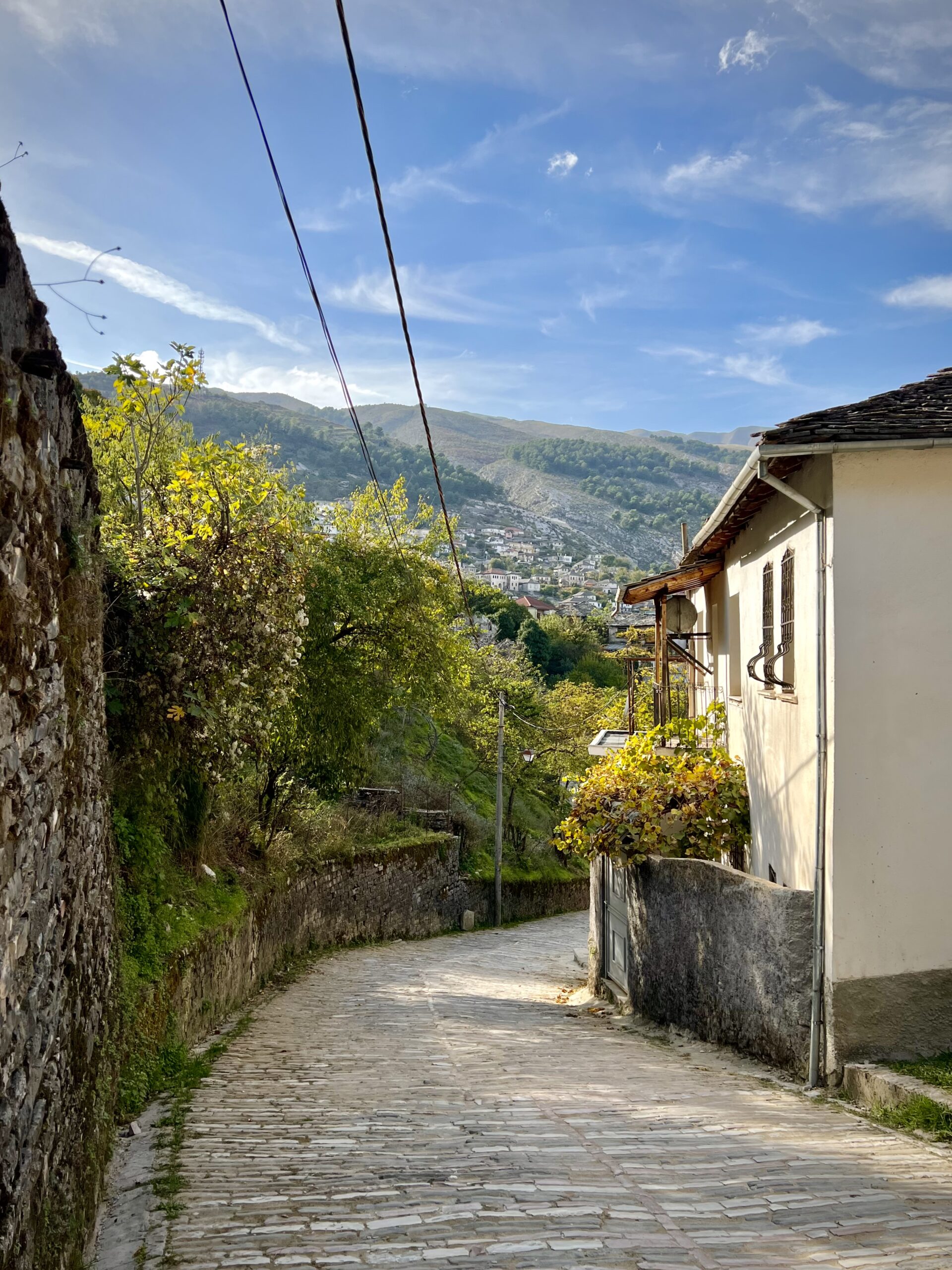 Historic street in Gjirokastër, Albania, showing everyday walking conditions and local buildings.