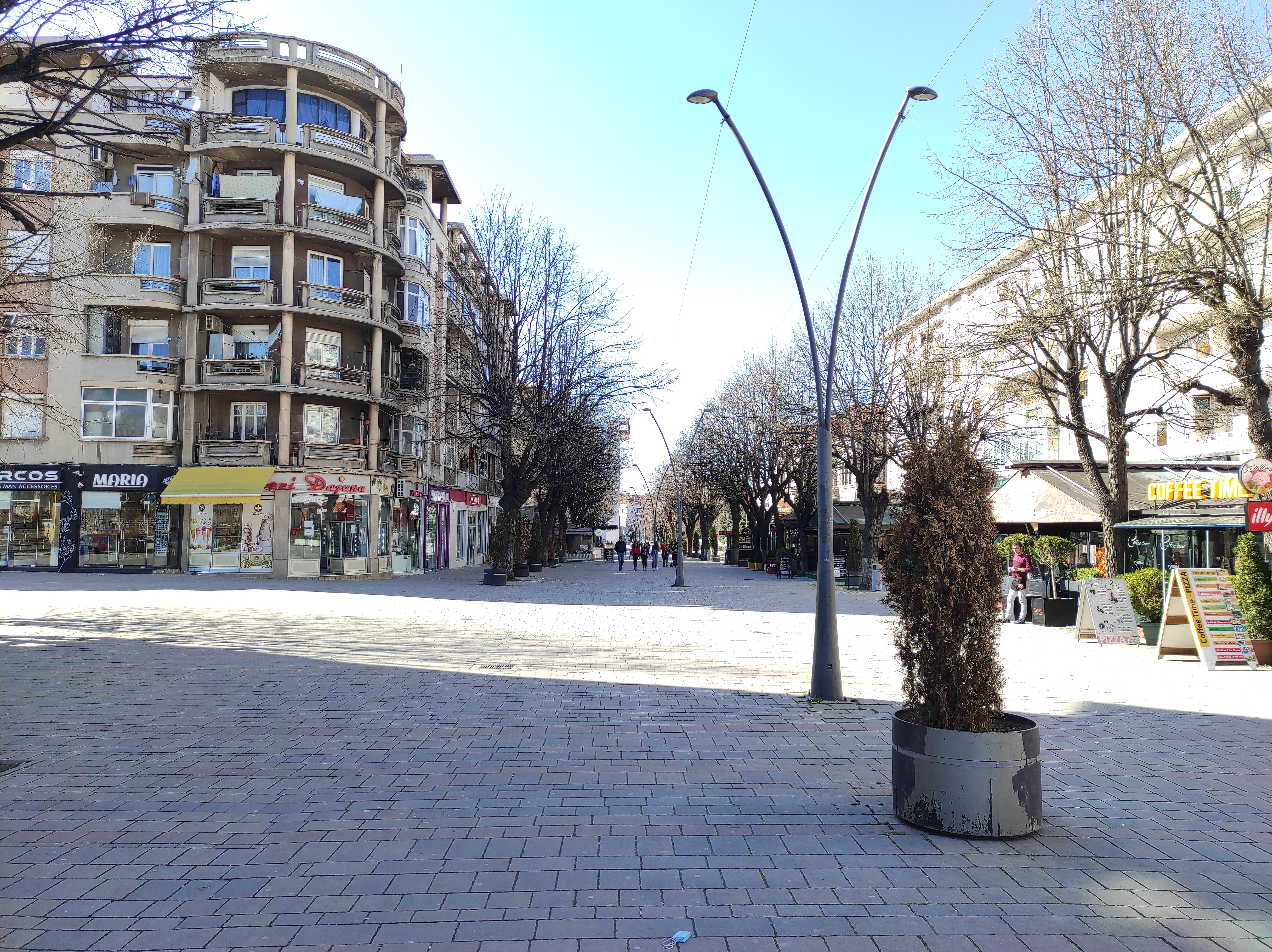 Pedestrian street with outdoor seating and an everyday city-center feel that suggests practical foot traffic rather than a car-dominated area.