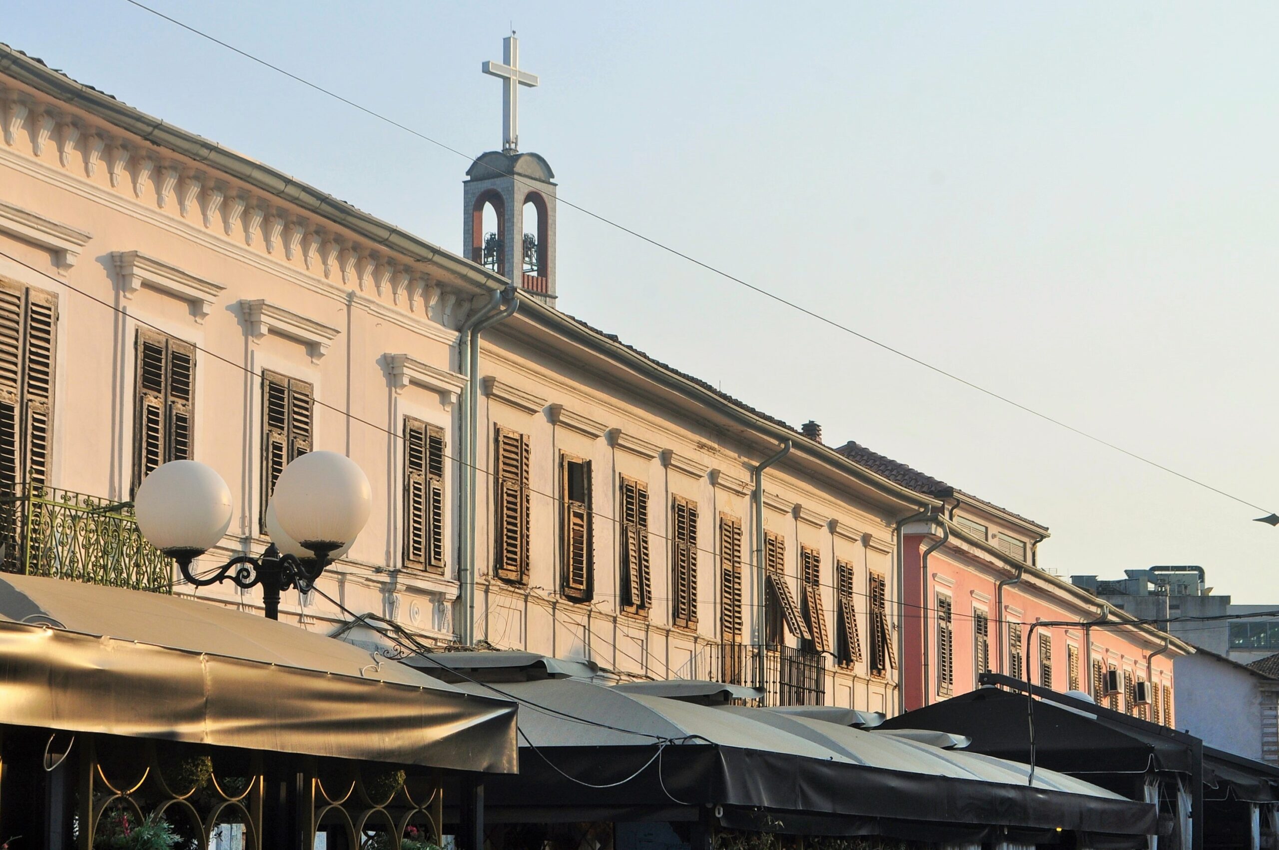 Pedestrian stretch of Kolë Idromeno Street in Shkodër with café seating and historic façades.
