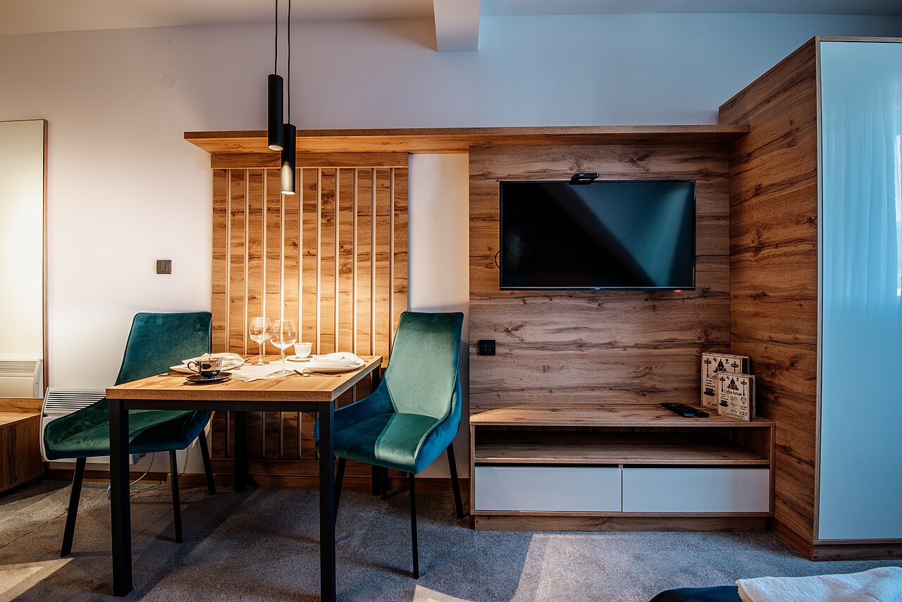 Modern furnished apartment dining and living area with shelving and table setup.