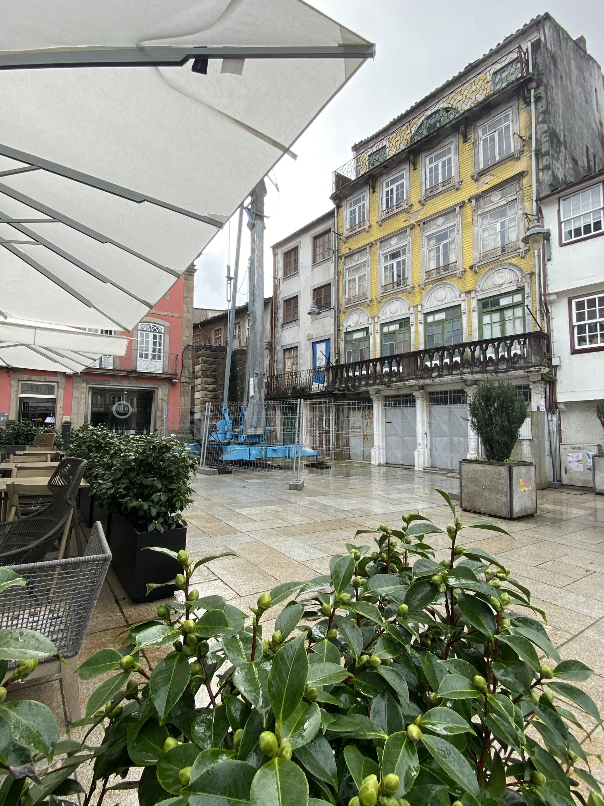 Historic square scene in Braga with cafés, old buildings, and pedestrians.
