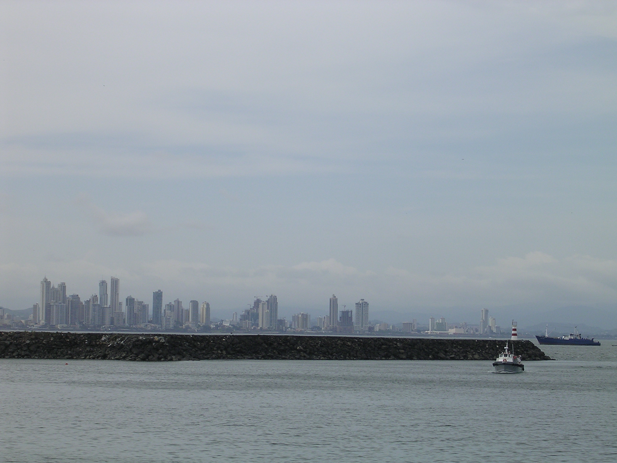 Panama City skyline viewed across the water with high-rises and boats along the waterfront.