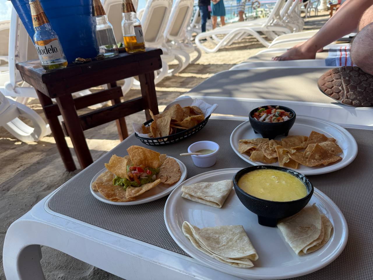 Table scene at The Krazy Lobster with food, drinks, and a beachside view in Costa Maya.