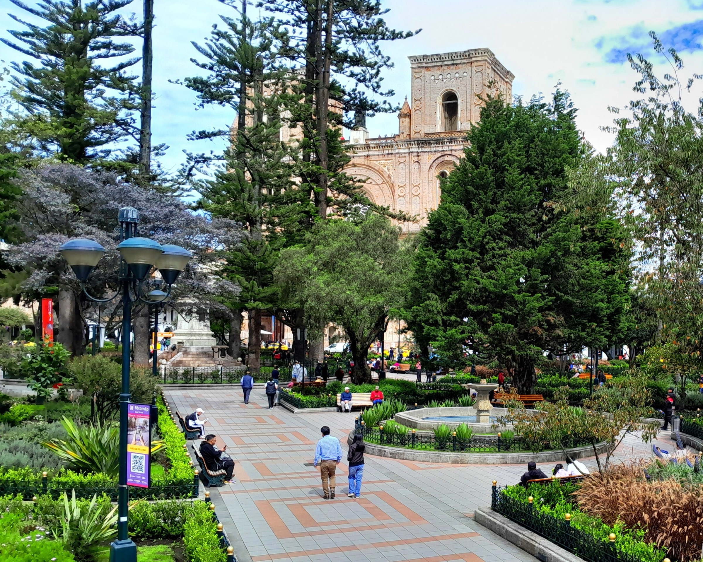 Morning scene at Parque Abdón Calderón in central Cuenca with trees and surrounding historic buildings.