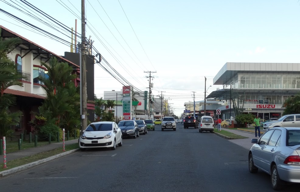Street scene in David, Panama with storefronts, traffic, and an everyday service-city feel.