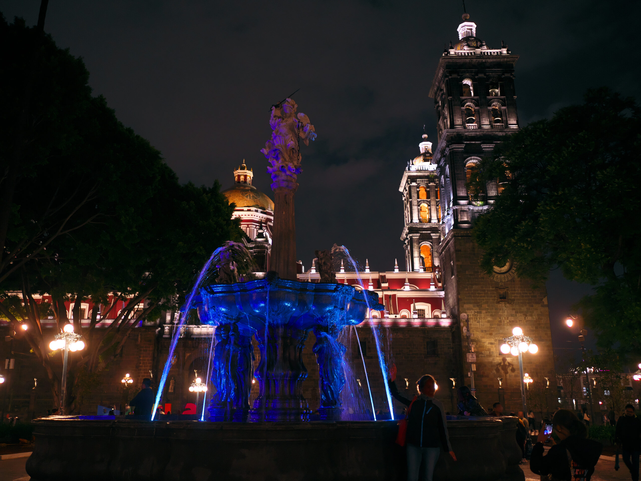 Night view across Puebla's central square and surrounding city buildings.