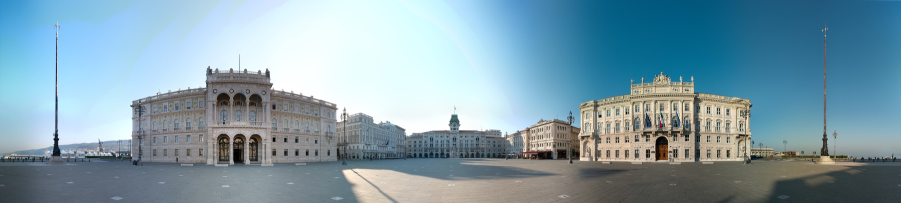 Panoramic view of Trieste Piazza Unità d’Italia facing the waterfront under bright light.