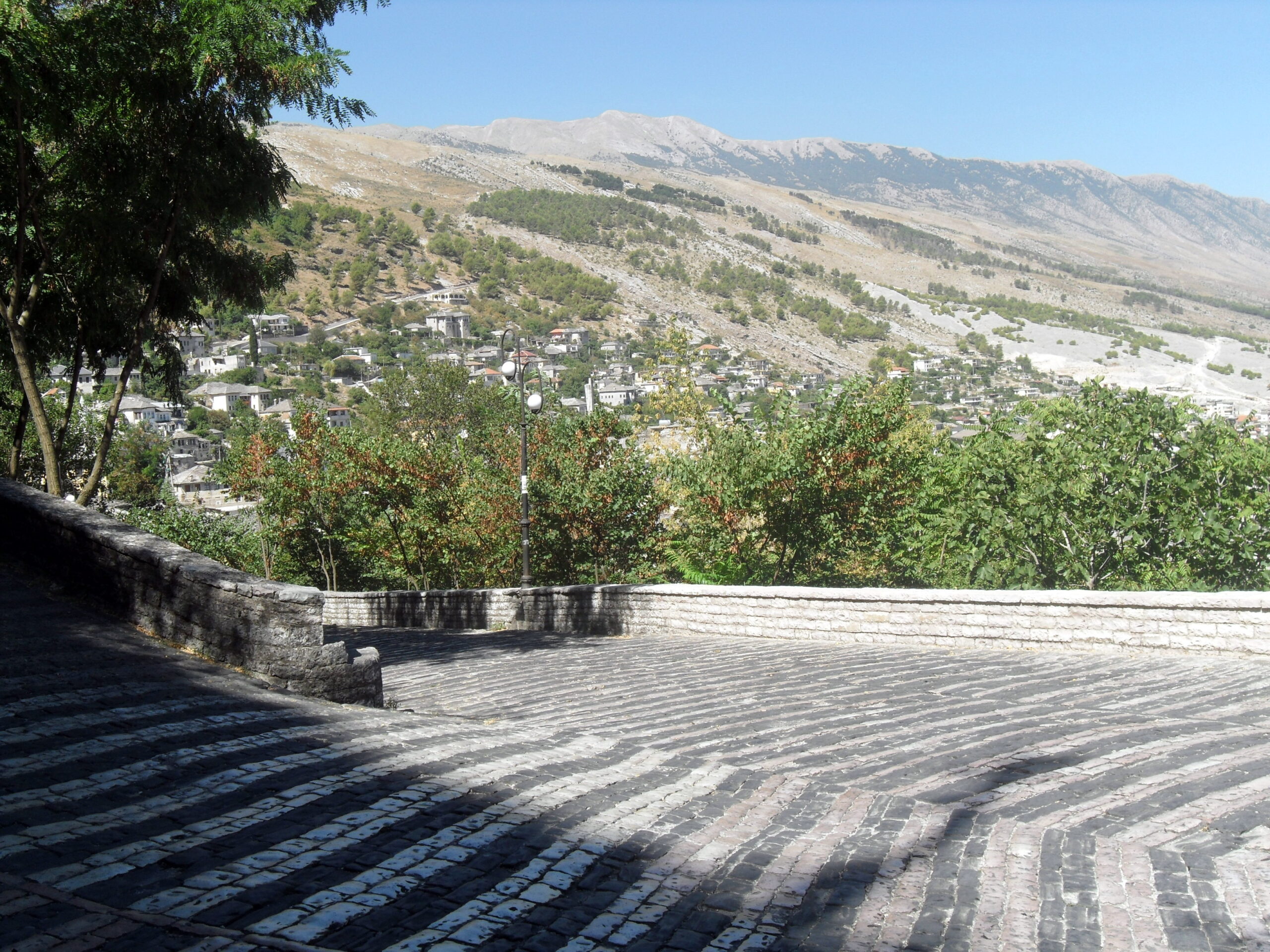 Steep stone street climbing toward the castle in Gjirokaster, Albania.