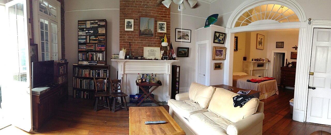 Apartment common area with seating, shelves, and enough room for ordinary daily routines.