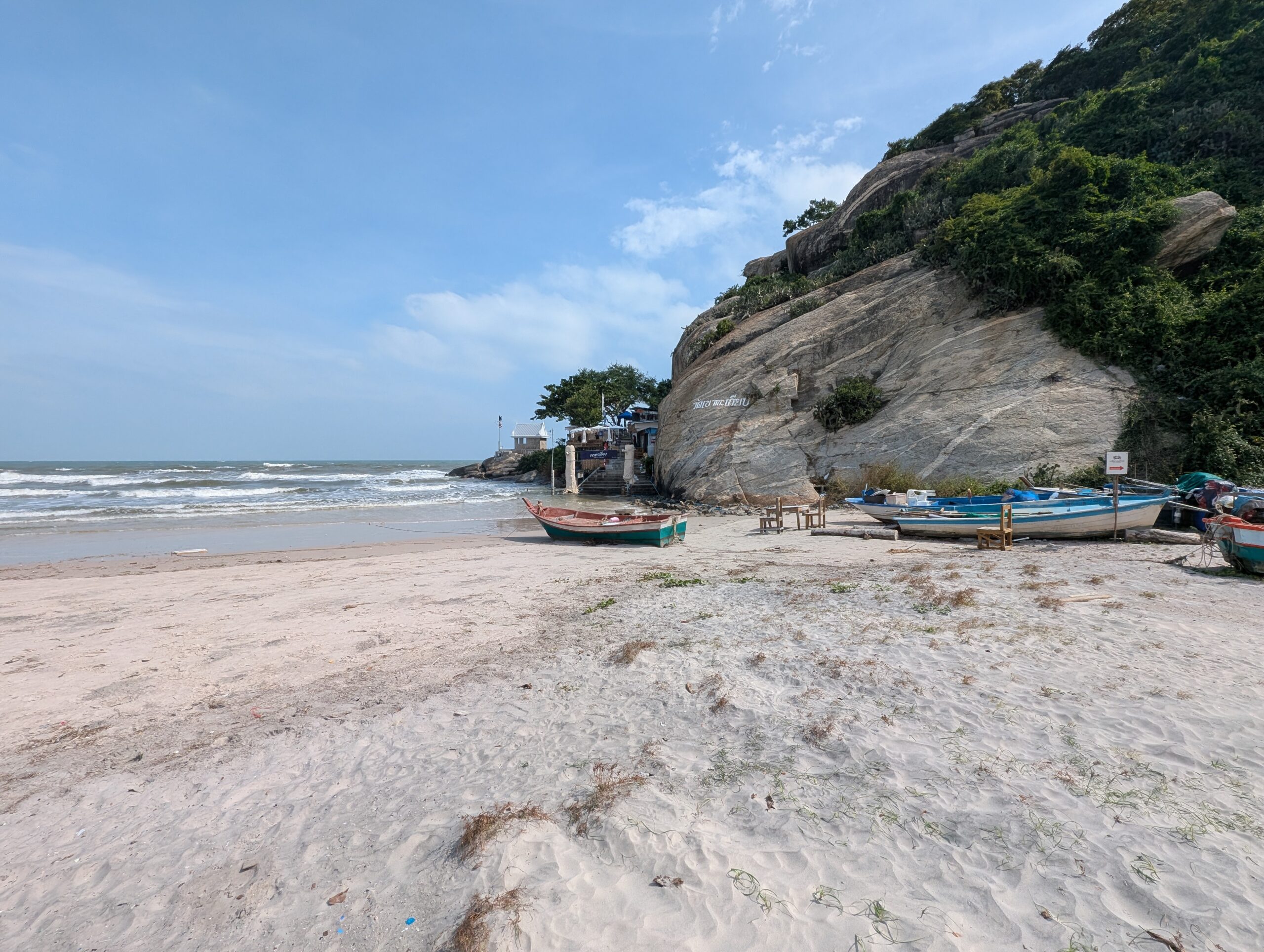 Sunny beach scene in Hua Hin with shoreline, sea, and open sky.