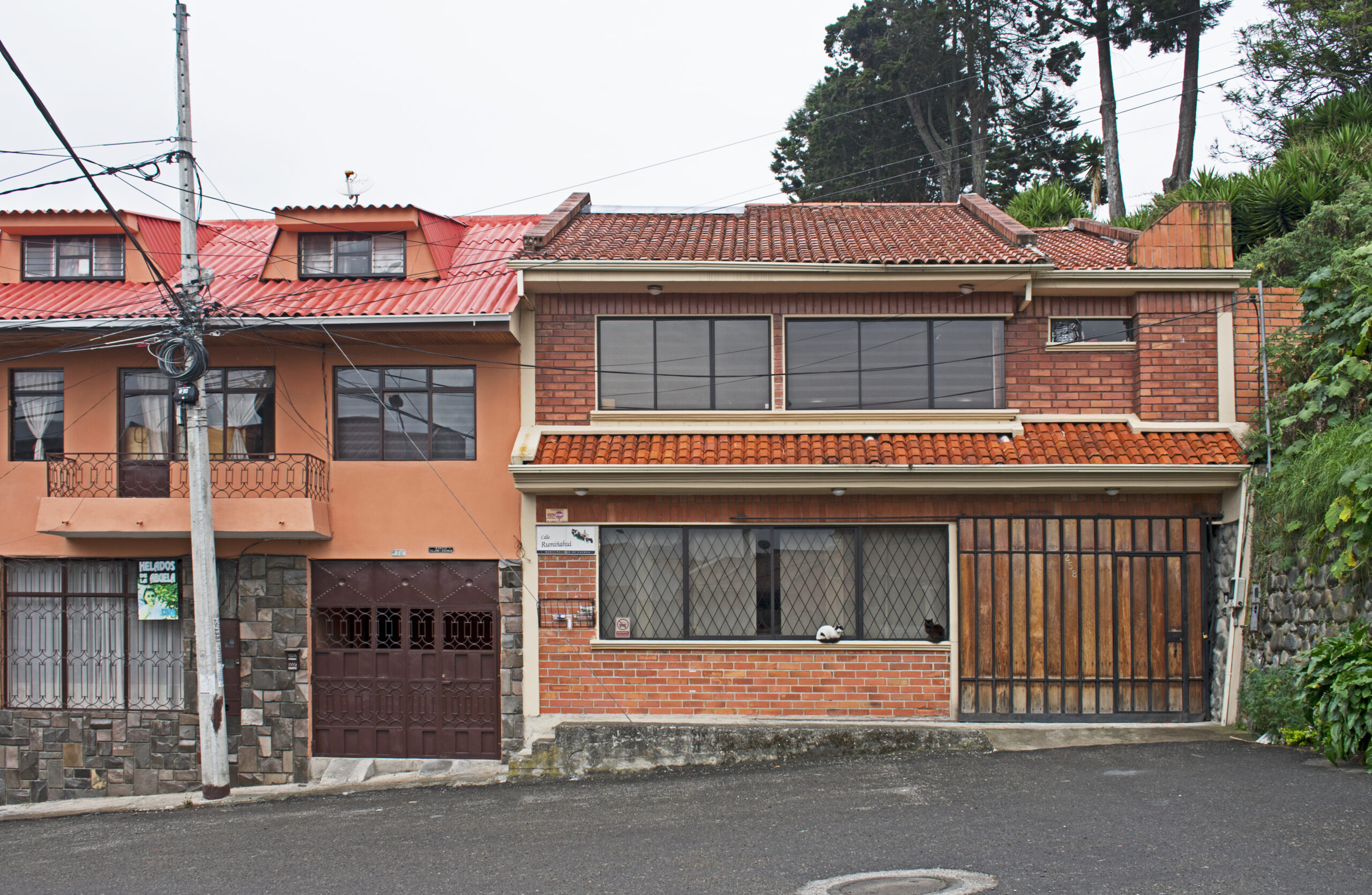 Residential street and hillside buildings on Calle Rumiñahui in Cuenca, Ecuador, showing ordinary highland neighborhood conditions.