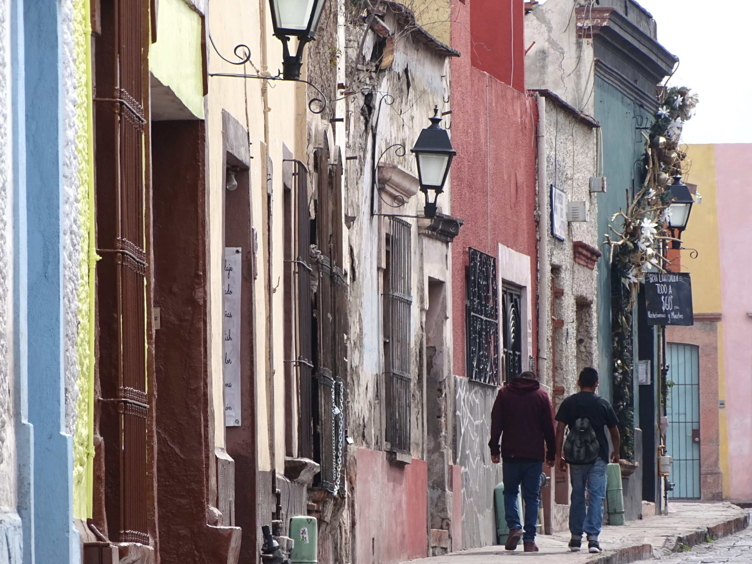 Pedestrians walking along a colorful street in Querétaro, Mexico, one of several Latin American city options for lower costs and mild high-desert climate.
