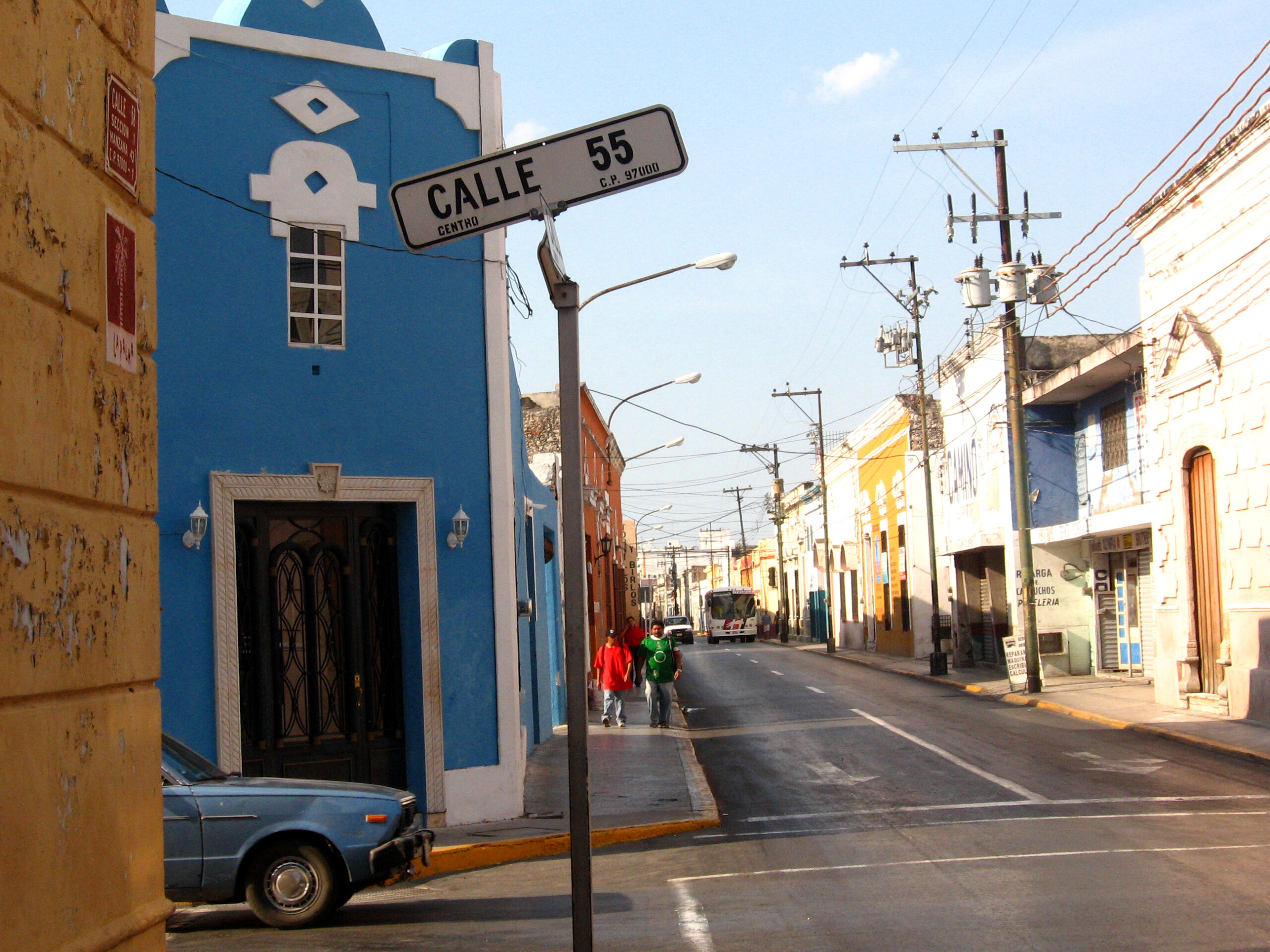Colorful street in Mérida, Yucatán with storefronts, signs, and a bright everyday-city feel.