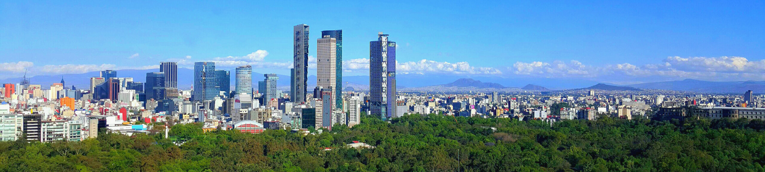 Wide Mexico City skyline over Reforma and Chapultepec under bright daylight.