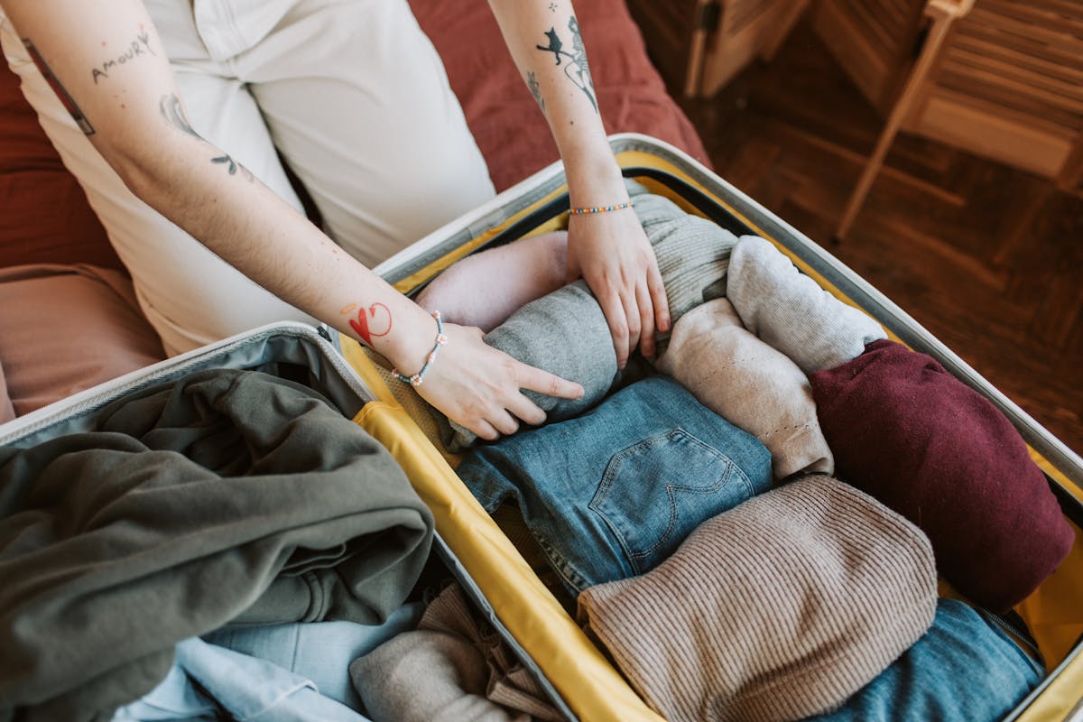 Rolled clothes and travel items being packed tightly into a suitcase.