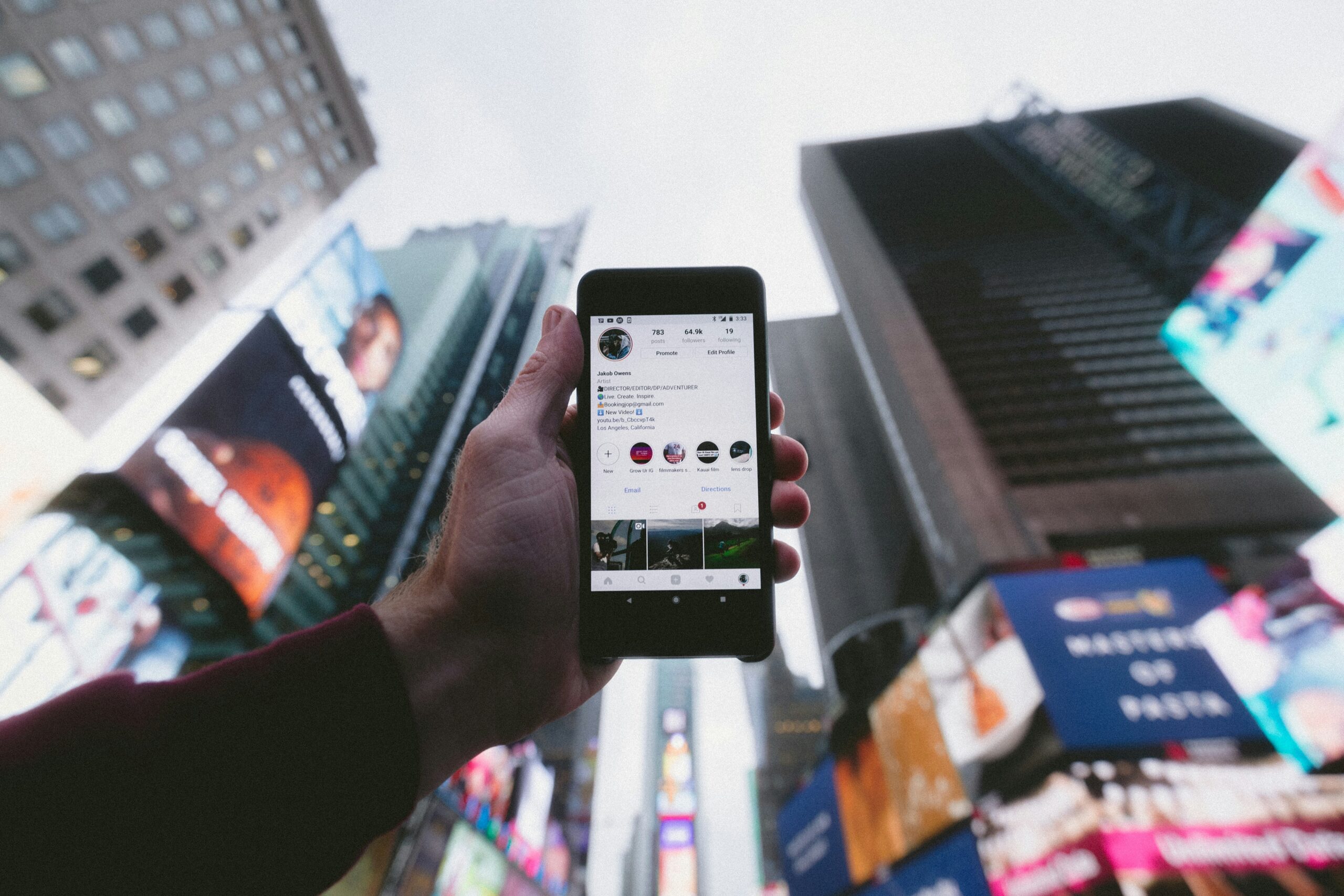 Person holding a smartphone in a city setting while using mobile service abroad.