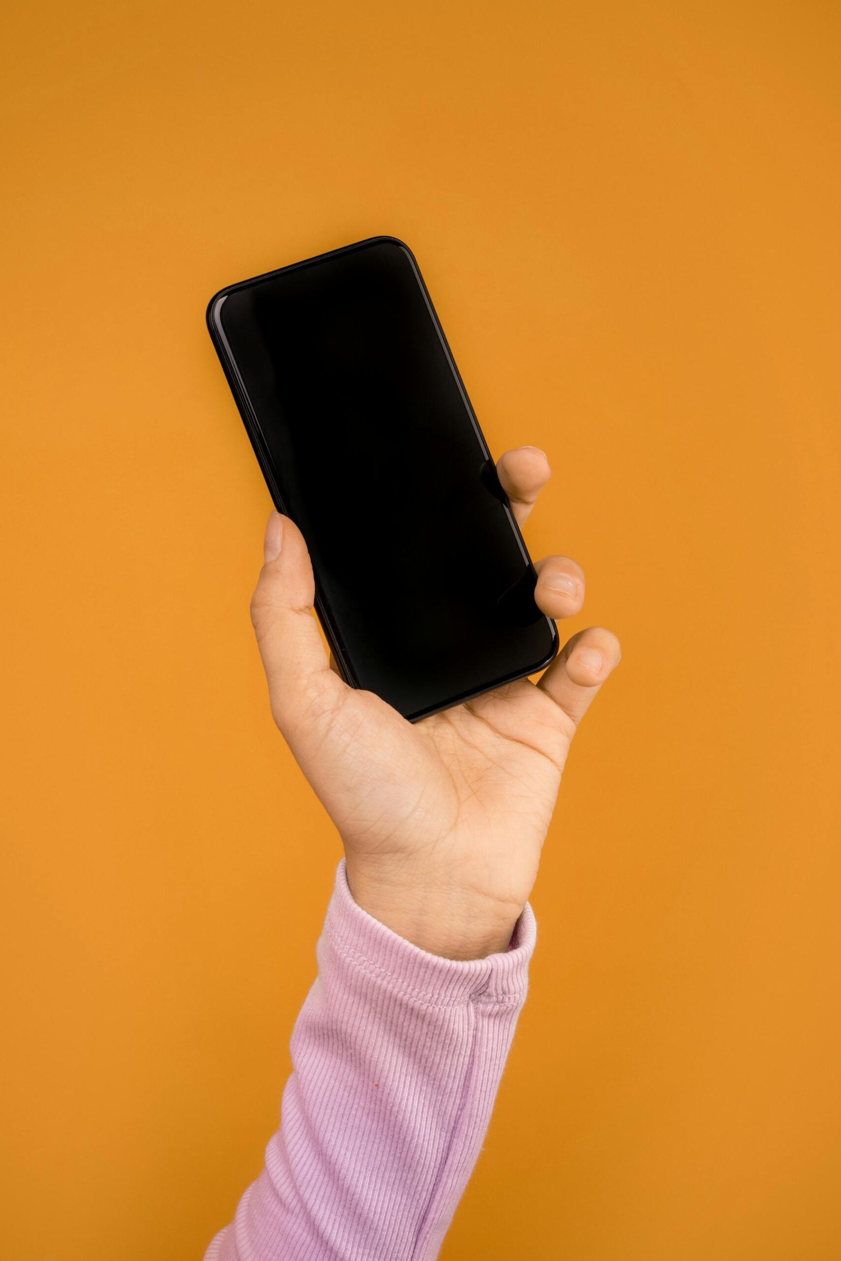 Close-up of a person holding a smartphone while checking phone setup before travel.