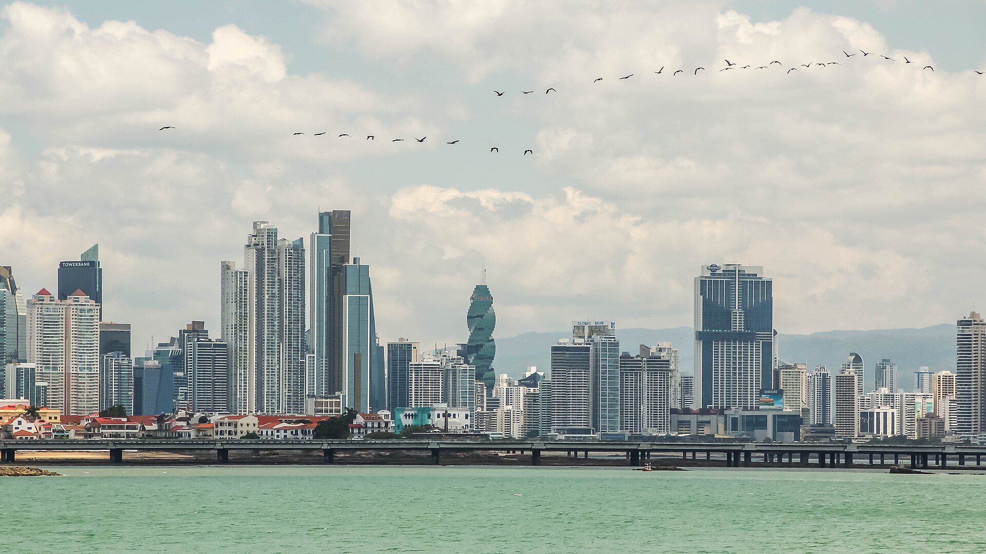 Panama City skyline with high-rise towers, bay water, and a bright daytime waterfront view.