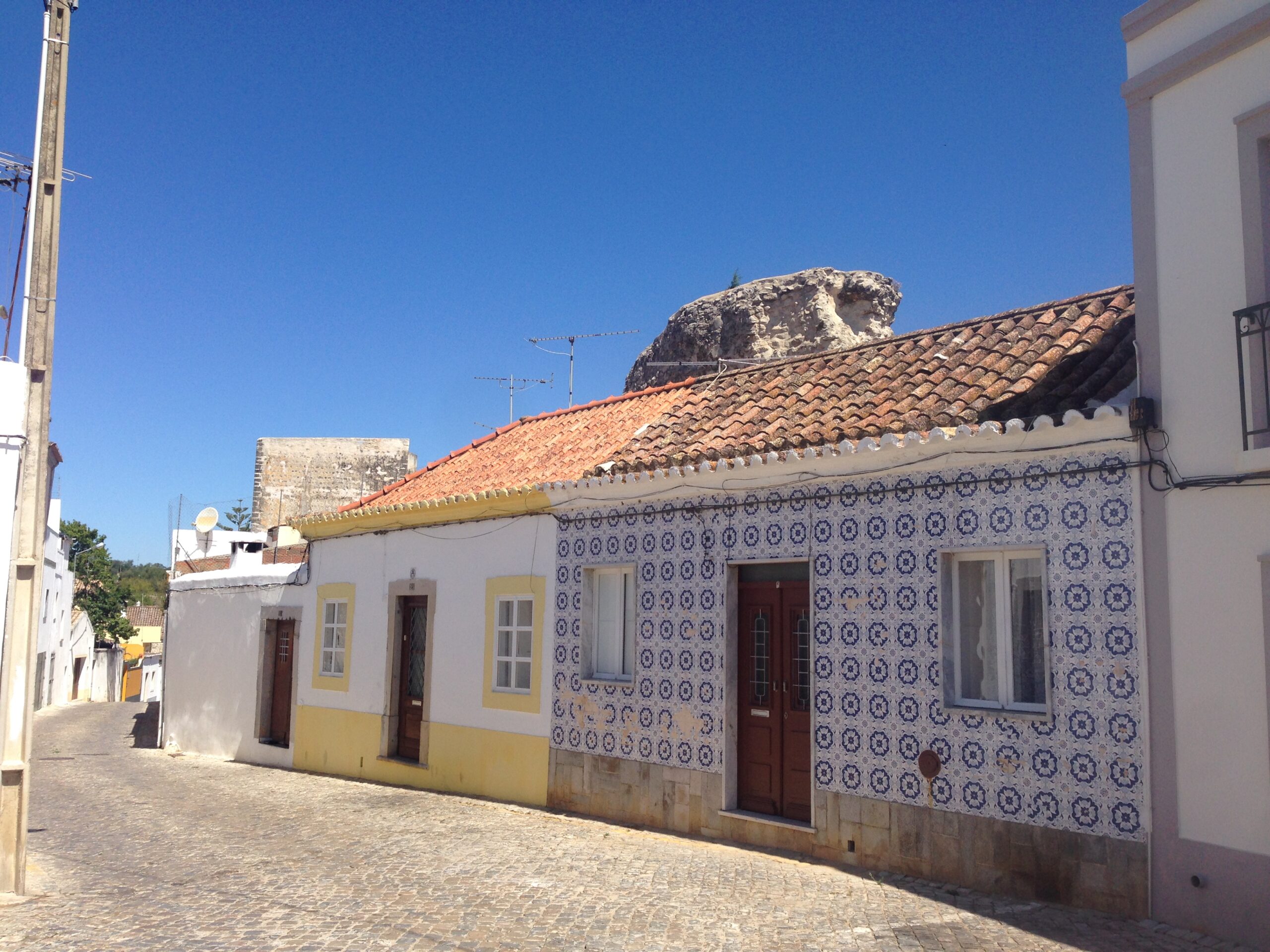 Street scene in Tavira with tile-fronted buildings and a slower small-city feel.