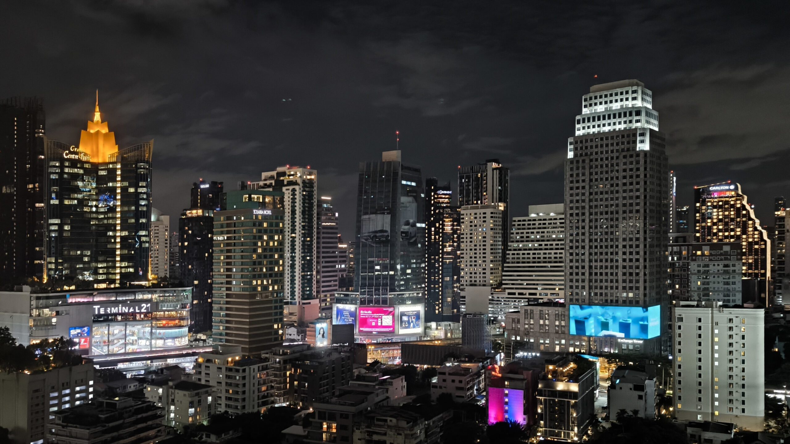 Bangkok skyline in daylight with modern towers, greenery, and a broad city view.