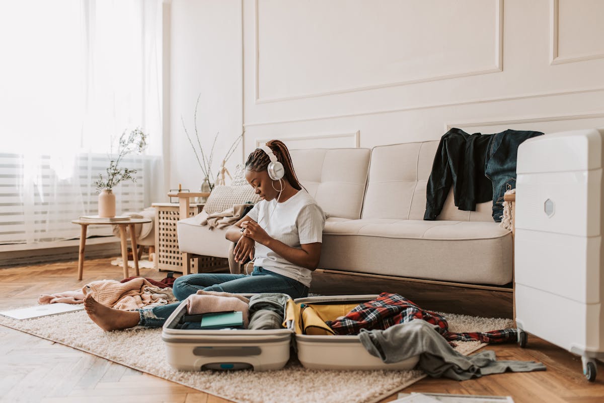 Travel items and clothing arranged neatly during packing for a longer apartment stay abroad.