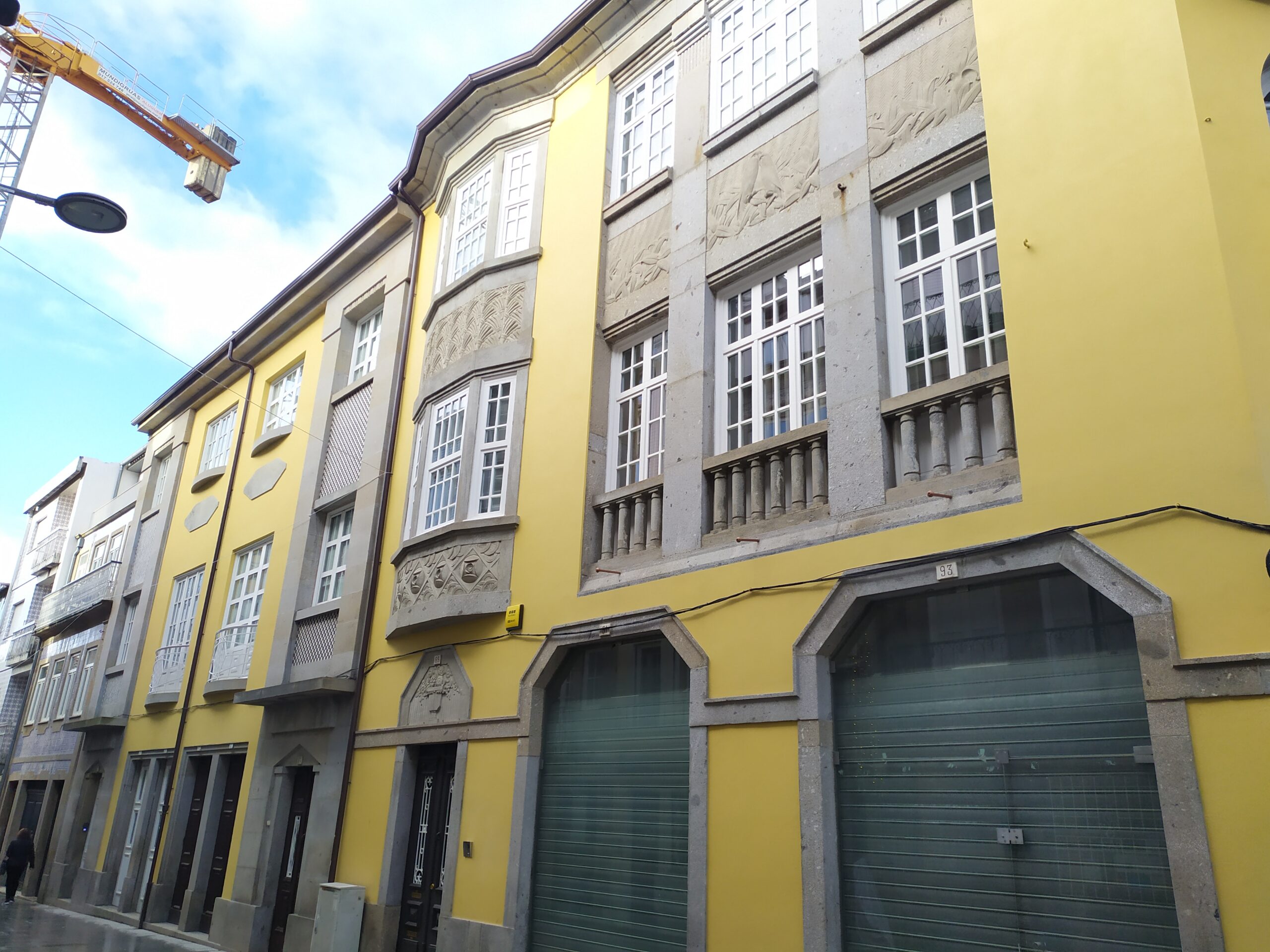 A quiet street in Braga, Portugal, with older buildings, parked cars, and everyday city life.