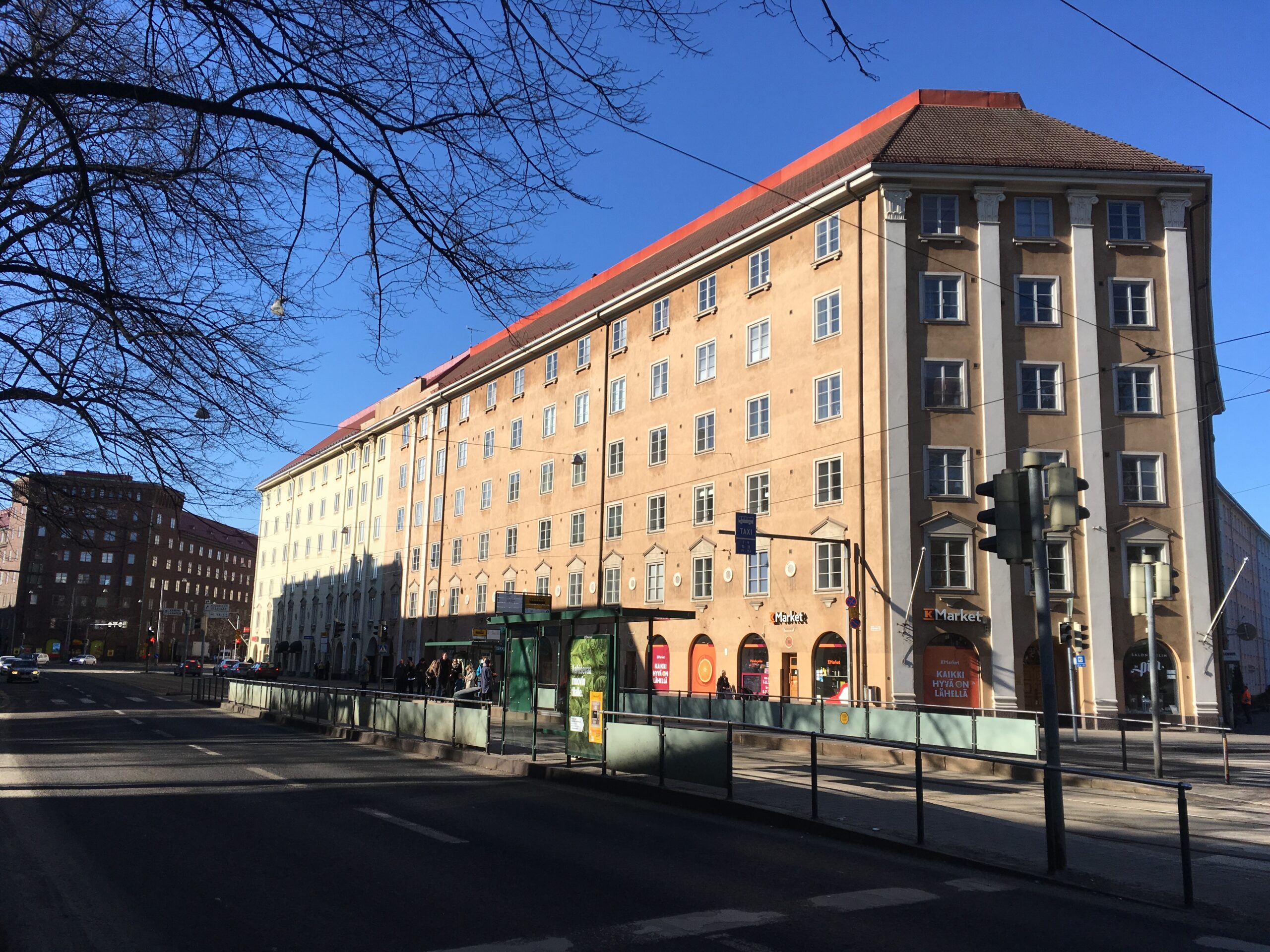 An apartment building with a ground-floor supermarket on an ordinary city street in Helsinki.