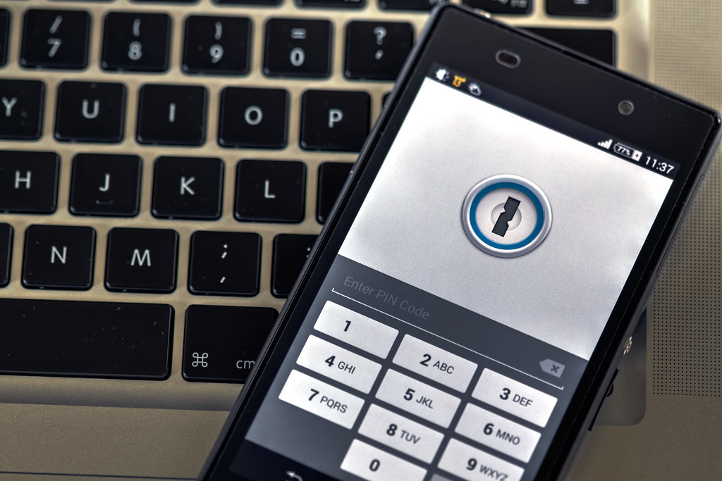 Phone security screen on a laptop keyboard while setting up account access before travel.