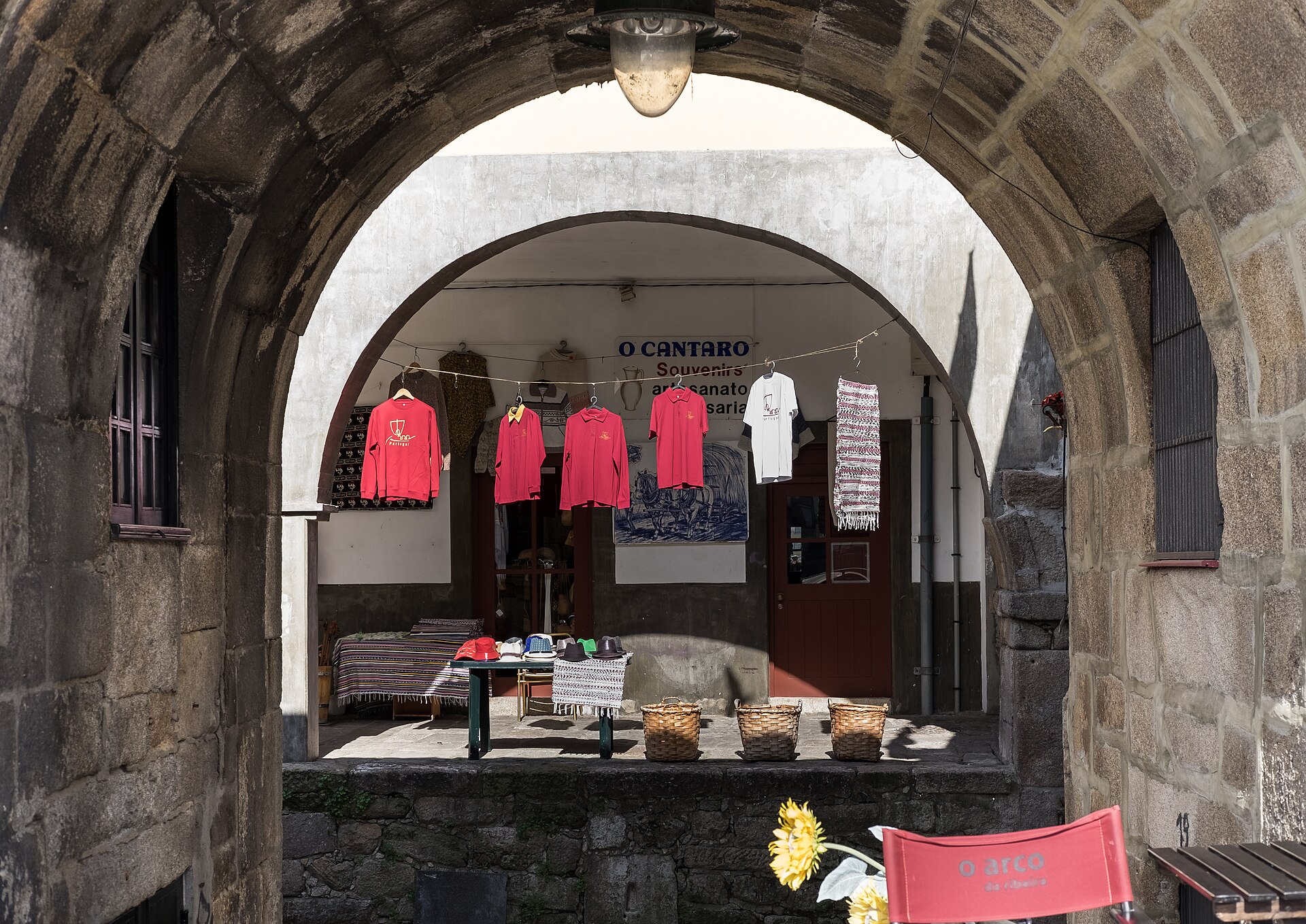 A stone archway and pedestrian street at Cais da Ribeira in Porto, Portugal.