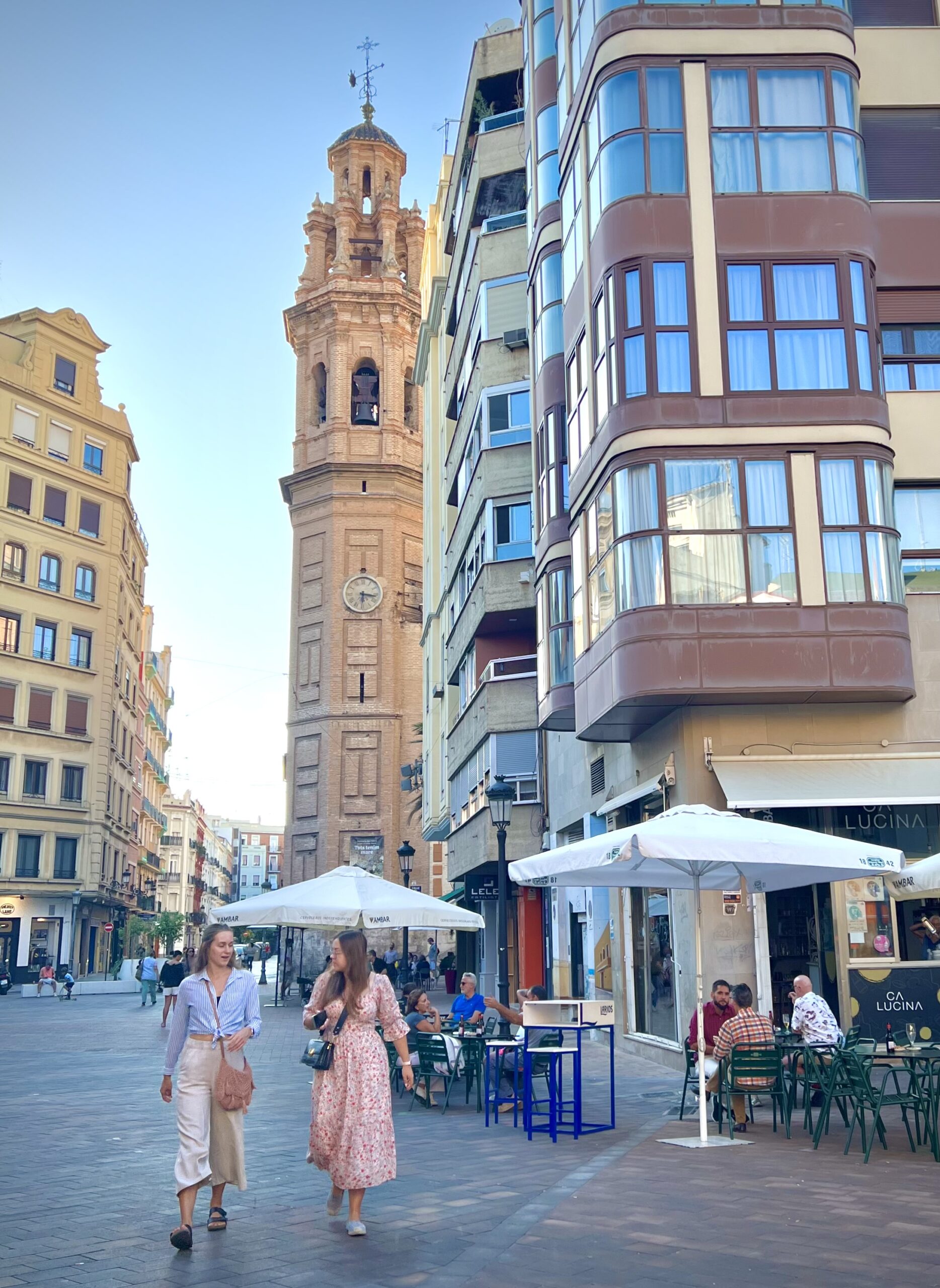 Pedestrians on a Valencia street, showing the everyday neighborhood context that affects rent, transport, errands, and livability.