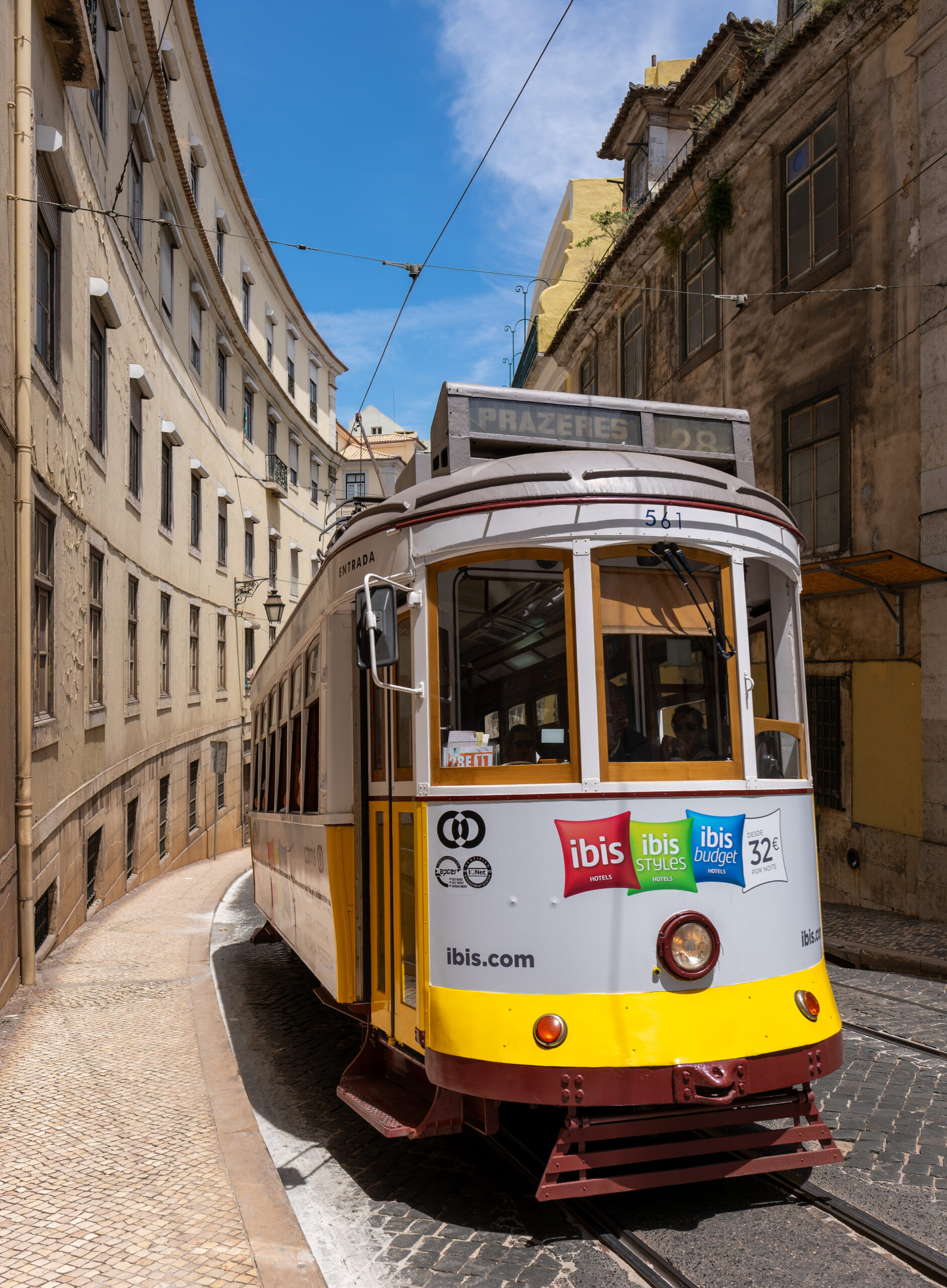 Number 28 tram on a narrow street in Lisbon, Portugal.