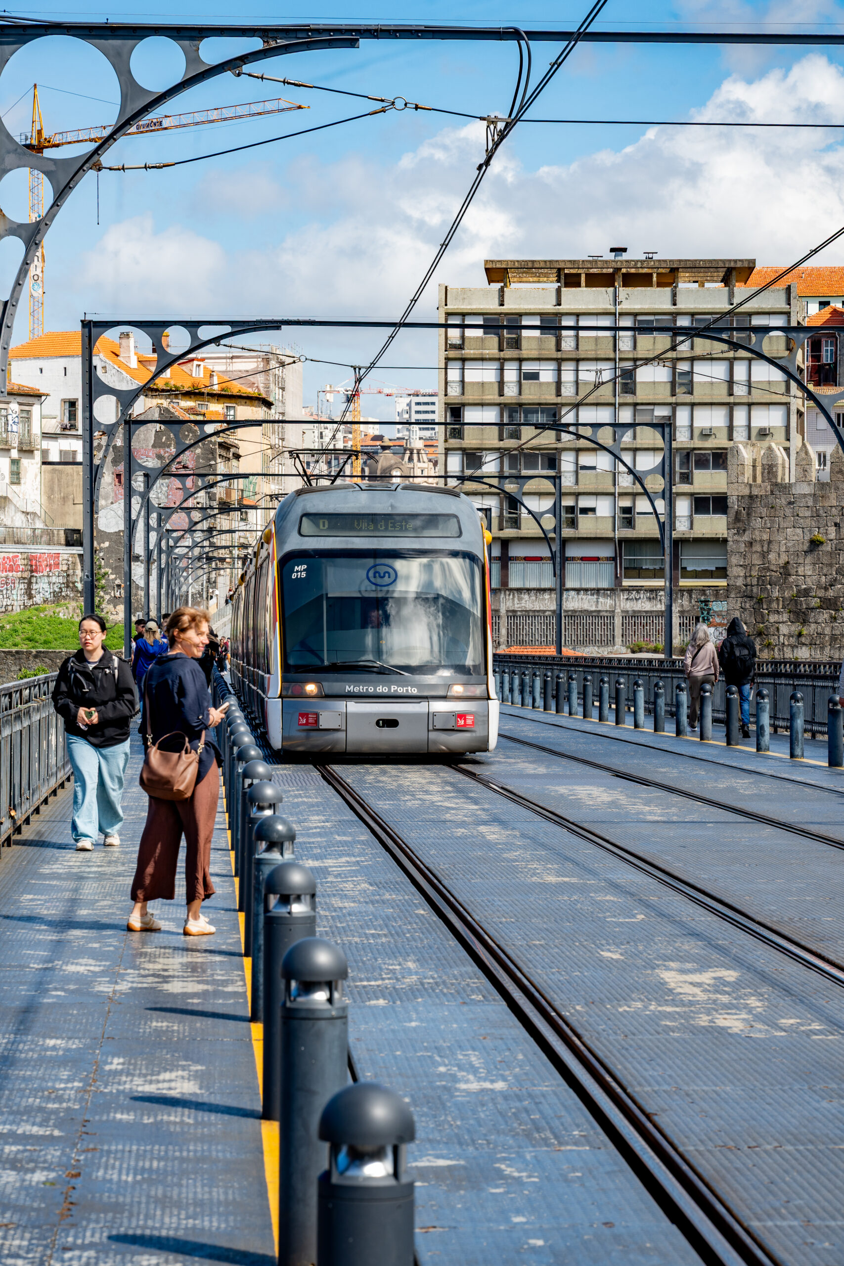 Modern tram crossing the Dom Luís I Bridge in Porto, Portugal.